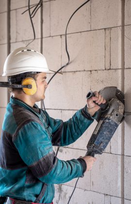 A handyman at a construction site works as a grinder.