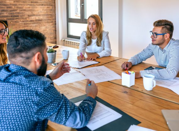 Businesspeople in a meeting looking at construction drawings