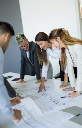 Team of architects working on construction plans Team of architects working on construction plans